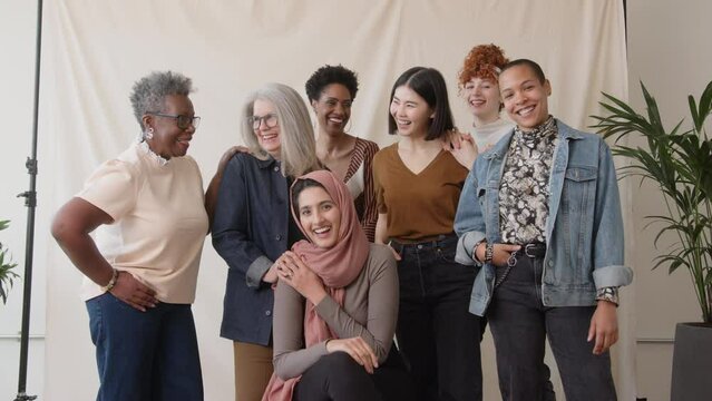 Slow motion of cheerful multiethnic women looking at camera and laughing, celebrating International Women's Day