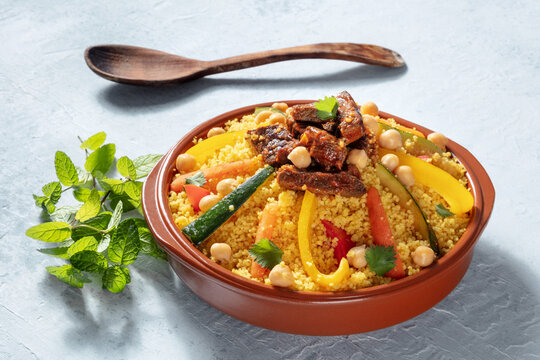 Meat and vegetable couscous, traditional Moroccan food, with fresh cilantro and mint. Festive Arabic dish
