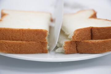 cutting toast bread isolated on white background, close-up view