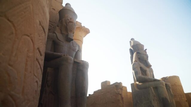 Tall statues in the Karnak Temple, Luxor Egypt. Intricate carved drawings and hieroglyphs adorning the wall.
Slow slide movement sideways. 