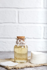 Mockup glass bottle with lotion and cotton pads for skin beauty care. Natural homemade cosmetic...
