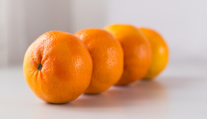appetizing tangerines laid out in a row on white background