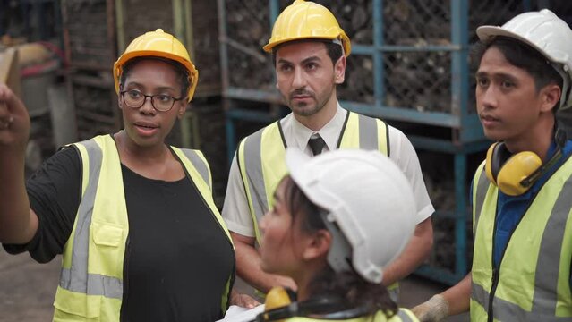 group of diversity warehouse worker meeting and checking list inventory in industry factory . eastern manager, african american clerk clipboard , asian man using tablet . teamwork of multiethnic