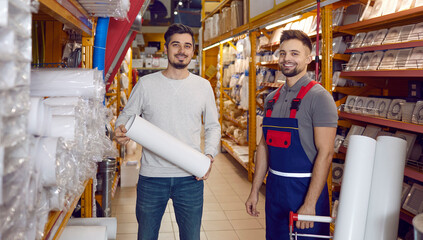 Young guy shopping for ventilation pipes at a modern DIY store. Two happy men, customer and...