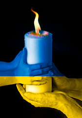 pray for ukraine - old hands and baby hands holding a candle
