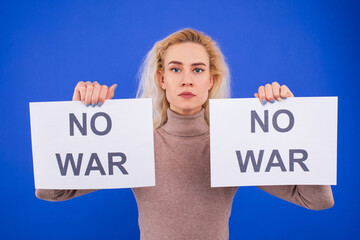 No war. Young woman with a posters on a blue background