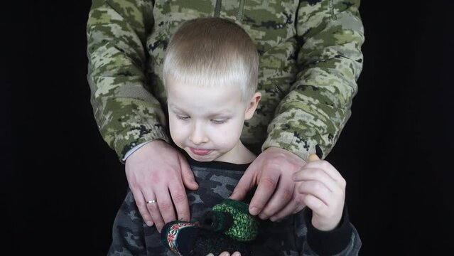 War in Ukraine. Military and children. Ukrainian soldier hugs a child. Army protects country population from invaders. Terrorist activities in the country. Camouflage uniform of Ukrainian military