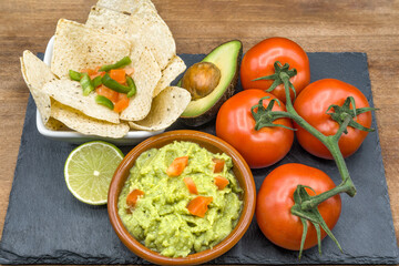 Homemade Organic Guacamole, tomatoes and Tortilla Chips. Selective focus.