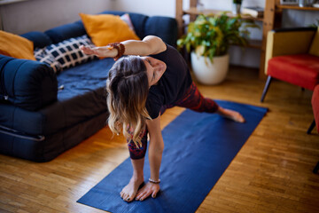 A flexible yogi woman practicing yoga at home.