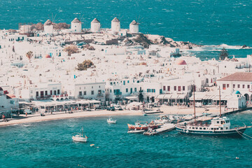 panoramic view of the Mykonos town harbor with famous windmills from the above hills on a sunny...