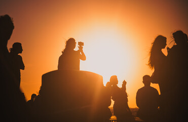 silhouettes of people taking pictures with smartphones