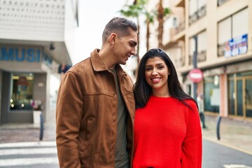 Man and woman couple smiling confident hugging each other at street