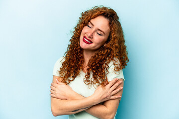 Young ginger caucasian woman isolated on blue background laughing and having fun.