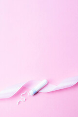 Tampons feminine hygiene. Pink ribbon with menstrual tampon on pink background. Sanitary hygiene concept. Menstruation feminine period. Menstruation, critical days, zero waste, eco, ecology banner.