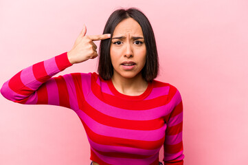 Young hispanic woman isolated on pink background showing a disappointment gesture with forefinger.