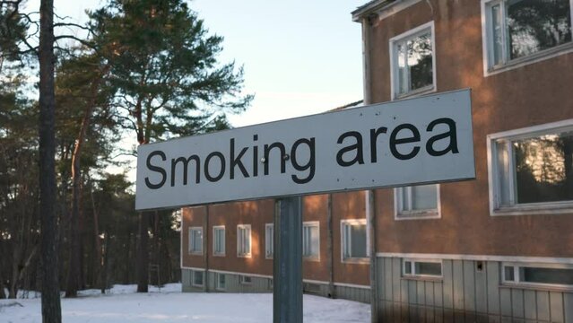 Smoking area sign in front of the old building. Close up