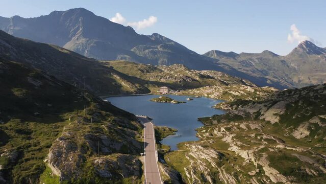 Aerial view of a lake on top of the San Bernardino mountain pass, in sunny Switzerland - tilt, drone shot