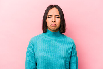 Fototapeta premium Young hispanic woman isolated on pink background sad, serious face, feeling miserable and displeased.
