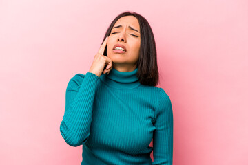 Young hispanic woman isolated on pink background crying, unhappy with something, agony and confusion concept.