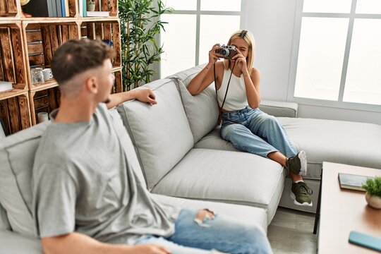 Woman making photo to her boyfriend using camera at home.