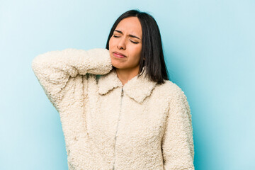 Young hispanic woman isolated on blue background having a neck pain due to stress, massaging and touching it with hand.