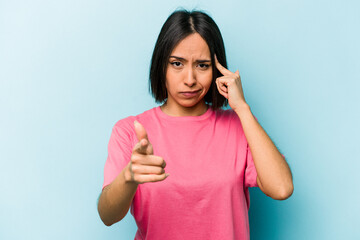 Fototapeta premium Young hispanic woman isolated on blue background pointing temple with finger, thinking, focused on a task.