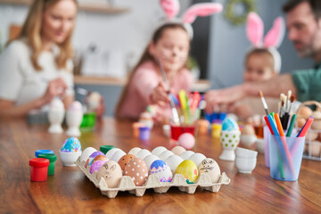 Colorful easter eggs in the foreground and family in the background