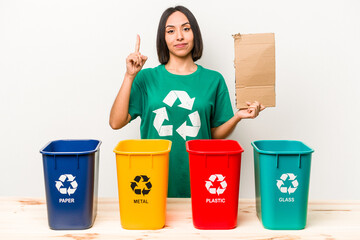 Young hispanic woman recycling cardboard isolated on white background