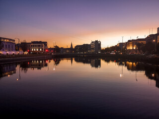 Sunset in Cork City Ireland business and classic buildings with reflection on the river