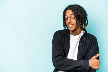 Young African American man isolated on blue background smiling confident with crossed arms.