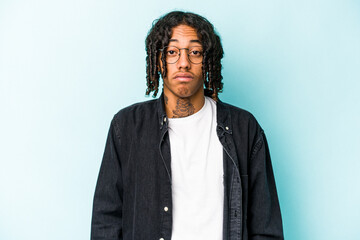 Young African American man isolated on blue background sad, serious face, feeling miserable and displeased.