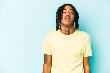 Young African American man isolated on blue background shouting very angry, rage concept, frustrated.
