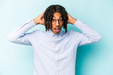 Young African American man isolated on blue background screaming, very excited, passionate, satisfied with something.