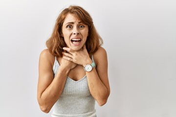 Beautiful caucasian woman standing over isolated background shouting suffocate because painful strangle. health problem. asphyxiate and suicide concept.