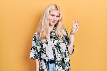 Beautiful caucasian woman with blond hair wearing tropical shirt showing and pointing up with fingers number four while smiling confident and happy.