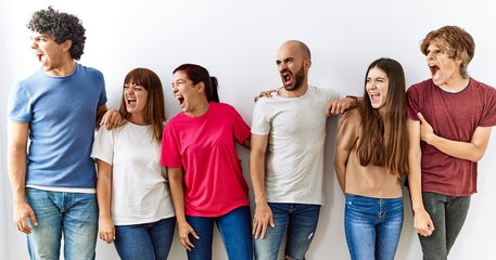 Group of young friends standing together over isolated background angry and mad screaming frustrated and furious, shouting with anger. rage and aggressive concept.