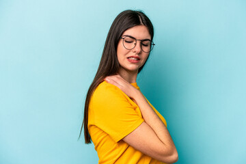 Young caucasian woman isolated on blue background having a shoulder pain.