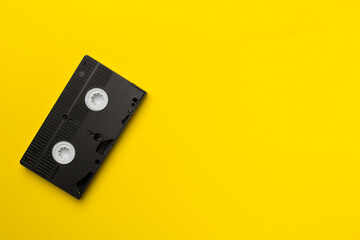 Old analog tape VHS cassette on color background, top view