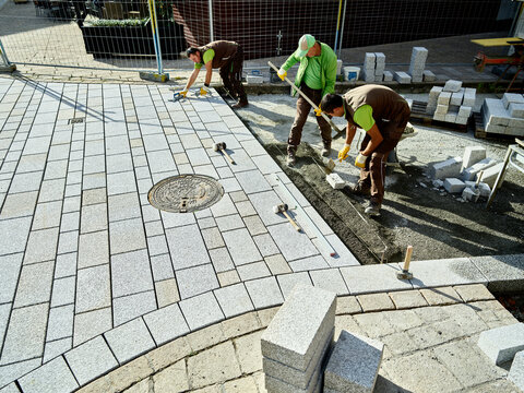 Pavers working on footpath to install paving stones