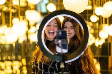 Influencer friends with ring light vlogging through smart phone