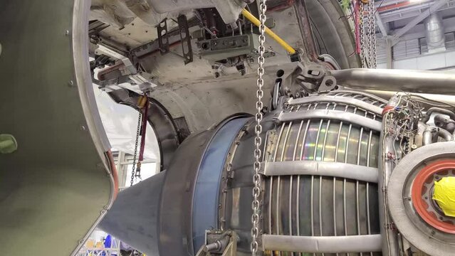Aircraft jet engine being wheeled into position under the engine cowls during an engine change.