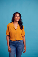 Portrait Of Mature Female Model Posing For Photographer Against Background On Studio Fashion Shoot