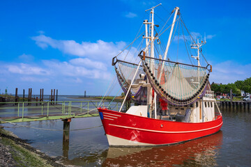 A red shrimp cutter in the port of Fedderwardersiel/Germany on the North Sea 
