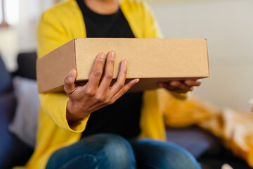 Woman holding cardboard box at home
