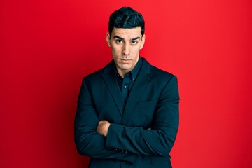 Handsome hispanic business man with arms crossed gesture skeptic and nervous, frowning upset...