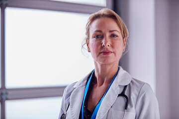 Portrait Of Mature Female Doctor Wearing White Coat In Hospital