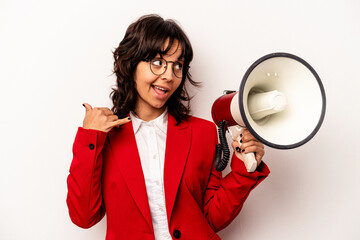 Young business hispanic woman holding an megaphone isolated on white background showing a mobile...
