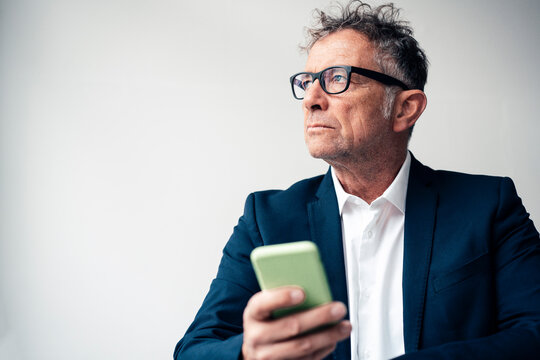 Businessman with mobile phone against white background