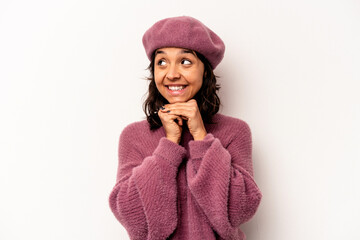 Young hispanic woman isolated on white background keeps hands under chin, is looking happily aside.