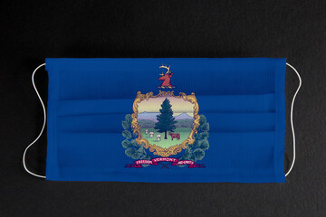Coronavirus Covid-19 in Vermont U.S. state. Flag of the State of Vermont printed on medical mask on...